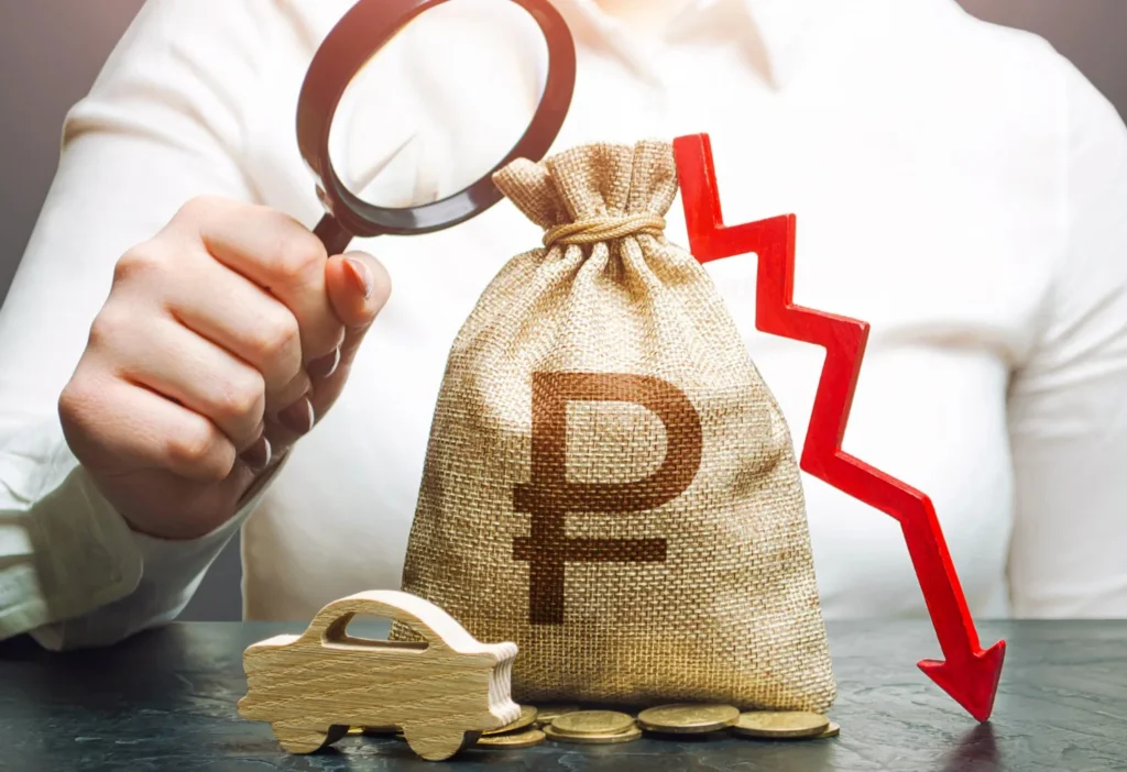 Magnifying glass examining a money bag with a currency symbol and a downward arrow, representing revenue loss and financial scrutiny.